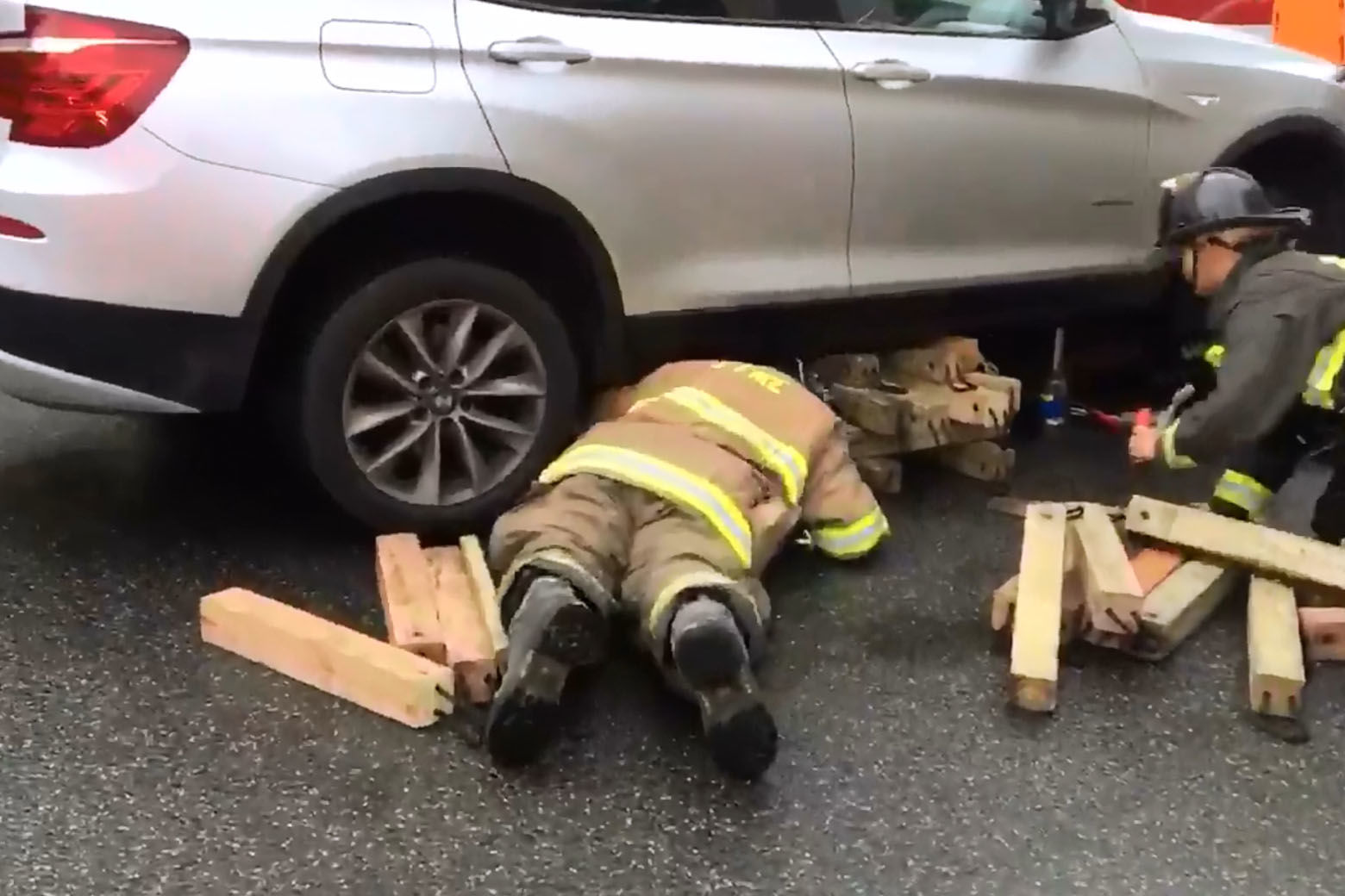 Videos tweeted by the D.C. Fire and EMS Service showed firefighters working to free the man who had become trapped under a silver SUV. (Courtesy D.C. Fire and EMS)
