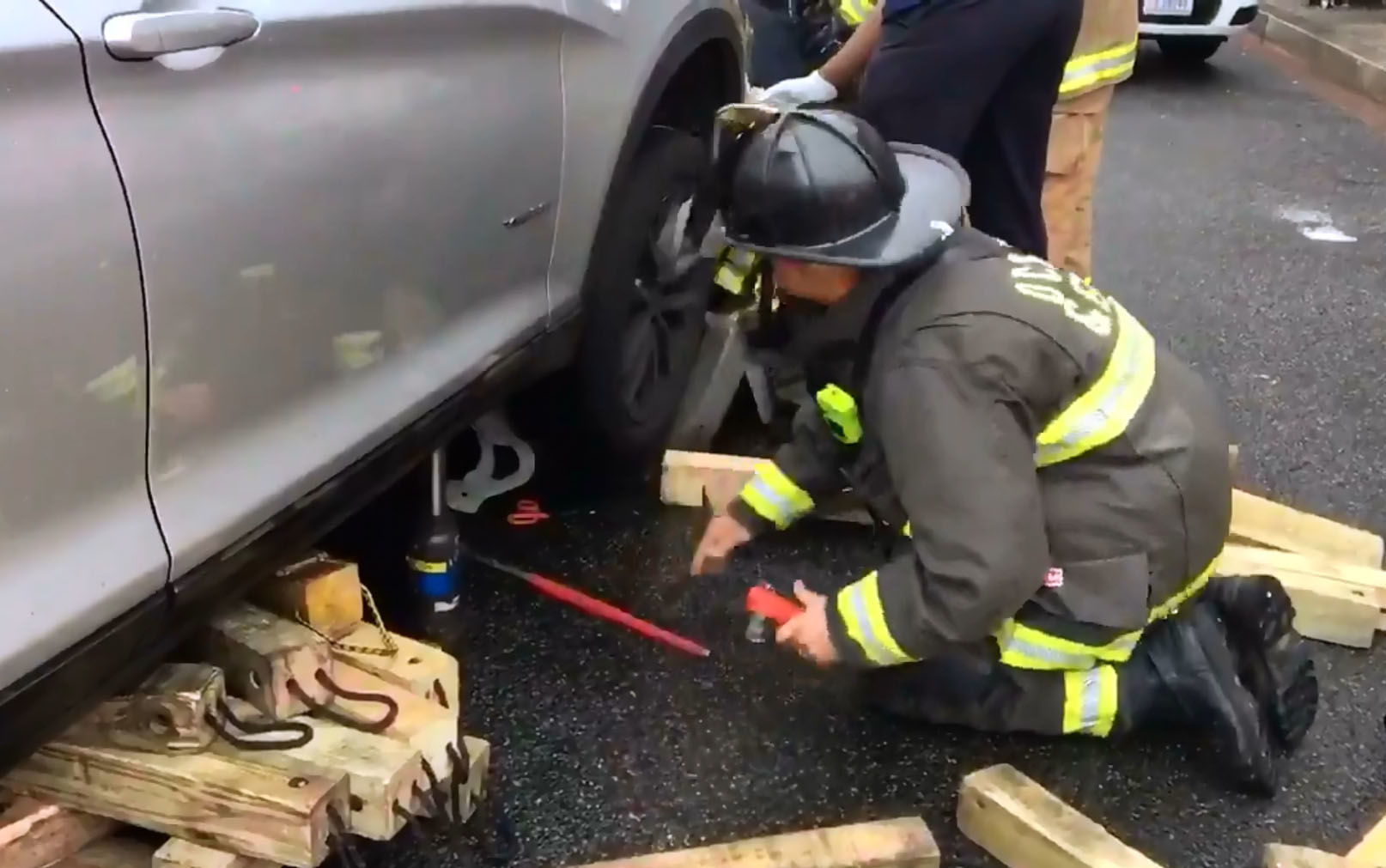 Videos tweeted by the D.C. Fire and EMS Service showed firefighters working to free the man who had become trapped under a silver SUV. (Courtesy D.C. Fire and EMS)