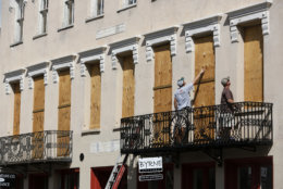 Derek Mundy, left, and Kris Crouse boards up the Confederate House in preparation for Hurricane Florence in downtown Charleston, S.C., Tuesday, Sept. 11, 2018. (AP Photo/Mic Smith)