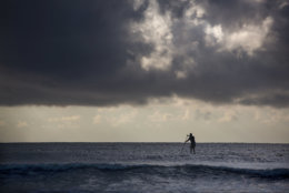 A paddle boarder gets in some exercise in the early morning off the beach at the Isle of Palms, S.C., as Hurricane Florence spins out in the Atlantic ocean Wednesday, Sept. 12, 2018.  The National Weather Service says Hurricane Florence "will likely be the storm of a lifetime for portions of the Carolina coast." (AP Photo/Mic Smith)