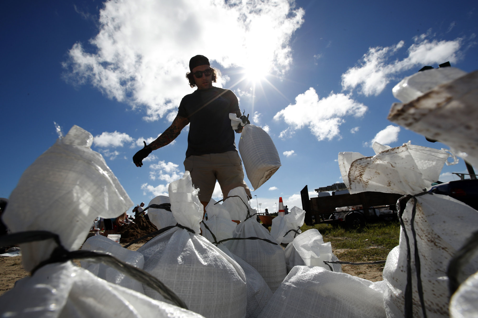 A Virginia Beach, Va., resident moves a sandbag before loading it in his truck, Wednesday, Sept. 12, 2018, in Virginia Beach, Va., as Hurricane Florence moves towards the eastern shore. The National Hurricane Center's projected track had Florence hovering off the southern North Carolina coast from Thursday night until landfall Saturday morning or so, about a day later than previously expected. The track also shifted somewhat south and west, throwing Georgia into peril as Florence moves inland. (AP Photo/Alex Brandon)