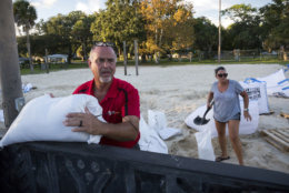 Tybee Island residents Sib McLellan, left, and his wife, Lisa McLellan, load sandbags into the back of their truck while preparing for Hurricane Florence, Wednesday, Sept., 12, 2018, on Tybee Island, Ga. (AP Photo/Stephen B. Morton)