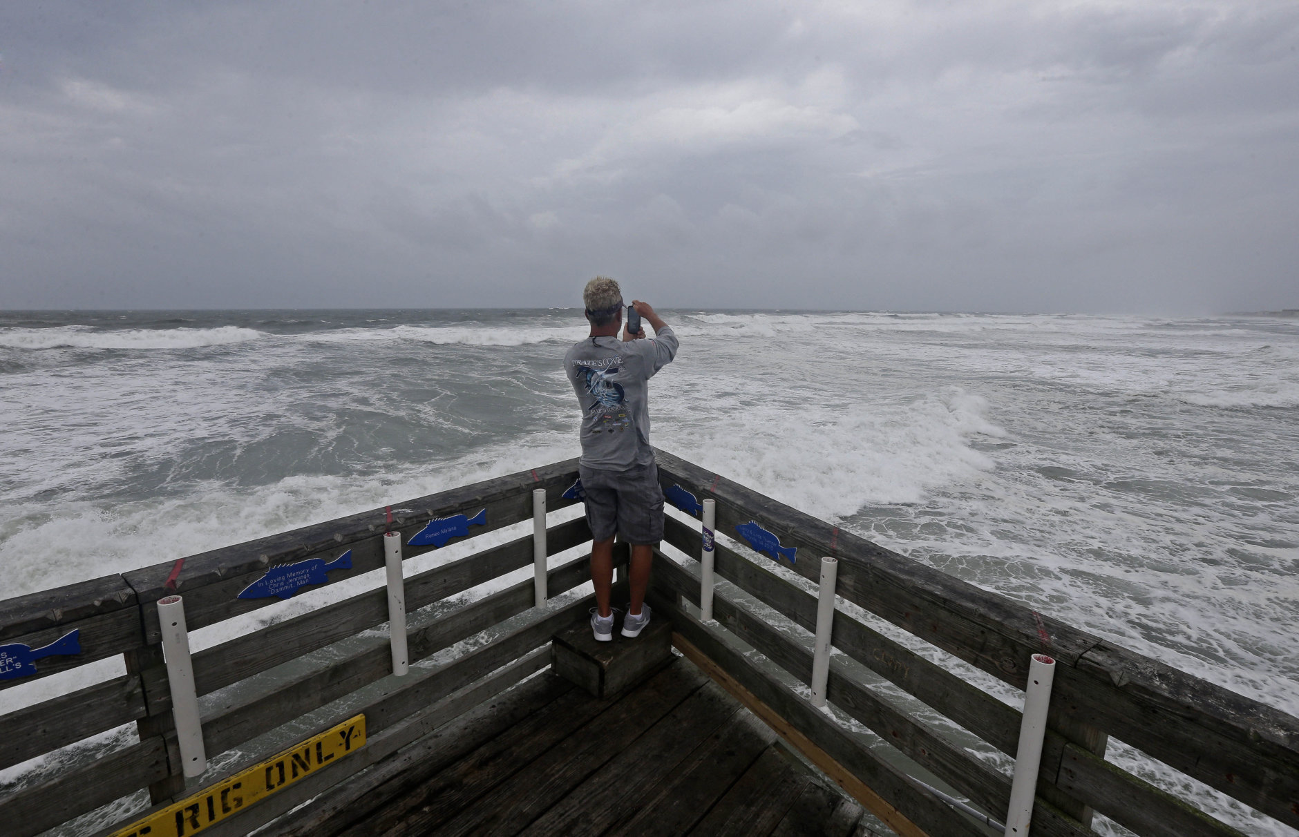 Patrick Wells looks out over the Atlantic ocean at the Avalon Fishing Pier in Kill Devil Hills, N.C., Thursday, Sept. 13, 2018 as Hurricane Florence approaches the east coast. (AP Photo/Gerry Broome)