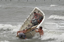 Fishermen launch a boat as they attempt to recover their haul-seine fishing net, Thursday, Sept. 13, 2018, in Virginia Beach, Va., as Hurricane Florence moves towards the eastern shore. (AP Photo/Alex Brandon)