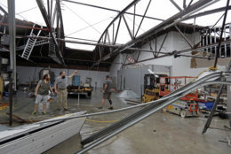 Ethan Hall, right, Michael Jenkins, center, and Nash Fralick, left, examine damage to Tidewater Brewing Co. in Wilmington, N.C., after Hurricane Florence made landfall Friday, Sept. 14, 2018. (AP Photo/Chuck Burton)