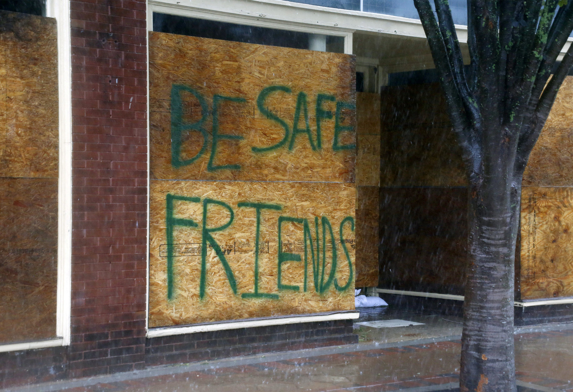 A message on a boarded-up business encourages people to be safe as Hurricane Florence hits downtown New Bern, N.C., on Friday, Sept. 14, 2018. (AP Photo/Chris Seward)