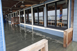 Sean Hayes, right, from Manteo, N.C., eats at Bubba's Seafood Restaurant with his family as the deck is covered with a few inches of water from effects of Hurricane Florence Friday, Sept. 14, 2018, in Virginia Beach, Va.  (AP Photo/Alex Brandon)