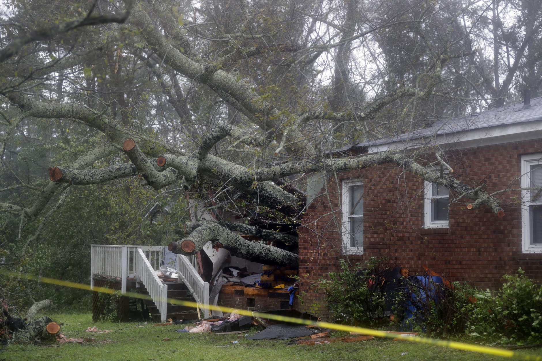 A fallen tree is shown after it crashed through the home where a woman and her baby were killed in Wilmington, N.C., after Hurricane Florence made landfall Friday, Sept. 14, 2018. (AP Photo/Chuck Burton)