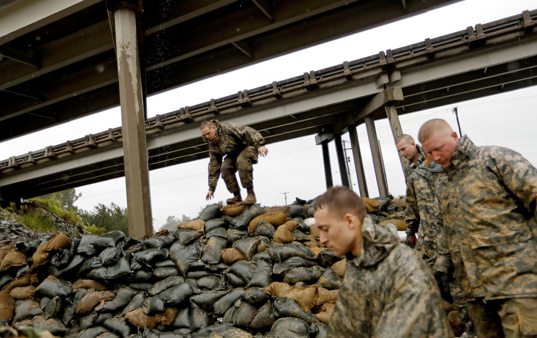 Members of the North Carolina National Guard finish stacking sand bags under a highway overpass near the Lumber River which is expected to flood from Hurricane Florence's rain in Lumberton, N.C., Friday, Sept. 14, 2018. (AP Photo/David Goldman)