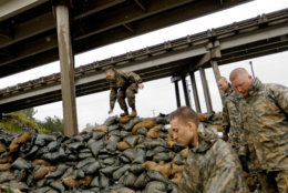 Members of the North Carolina National Guard finish stacking sand bags under a highway overpass near the Lumber River which is expected to flood from Hurricane Florence's rain in Lumberton, N.C., Friday, Sept. 14, 2018. (AP Photo/David Goldman)