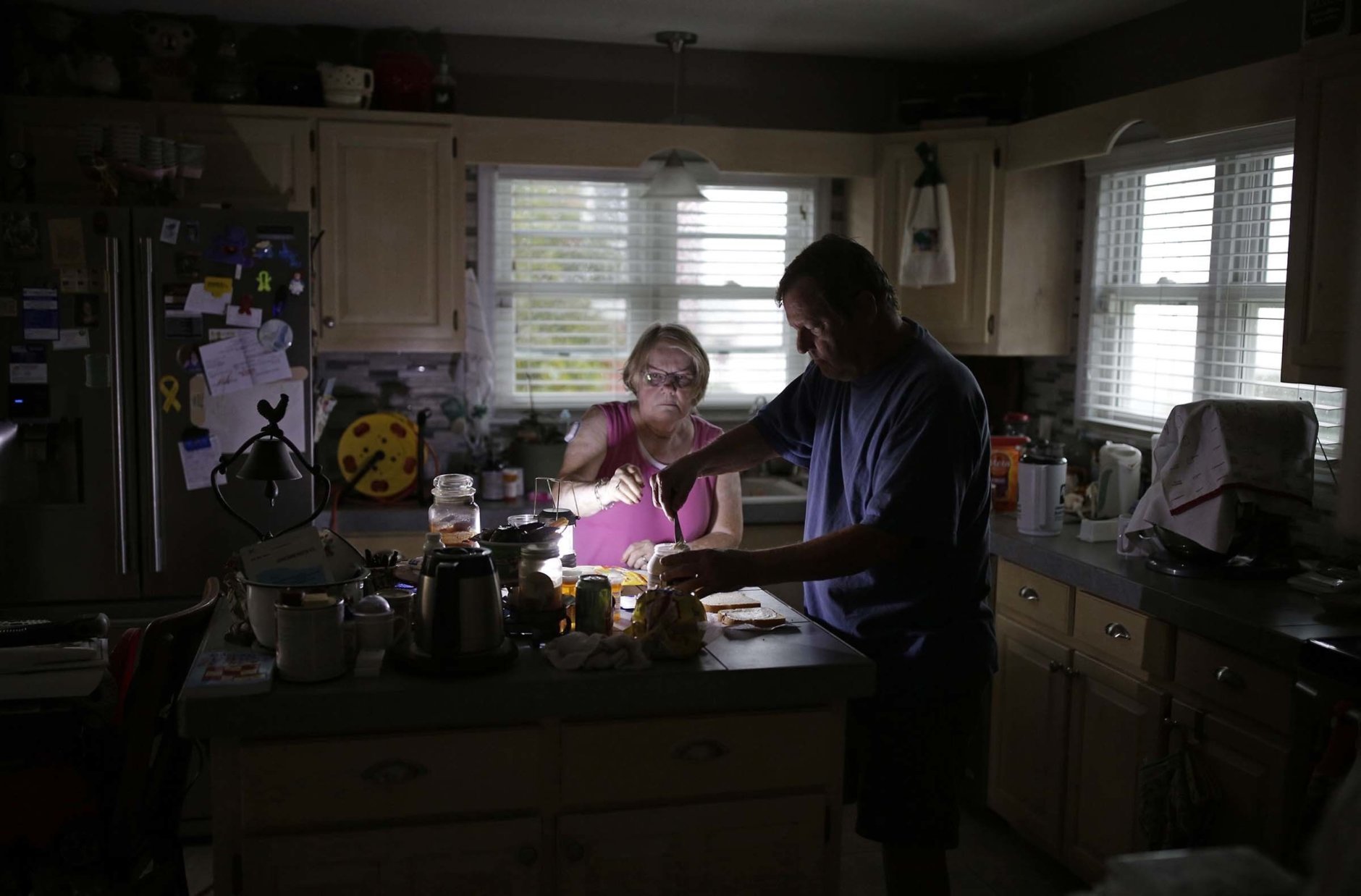 With use of a generator Ed and Nancy Schueren make dinner as they cope with no power and water after high winds and water from Hurricane Florence hit Swansboro N.C., Friday, Sept. 14, 2018. (AP Photo/Tom Copeland)