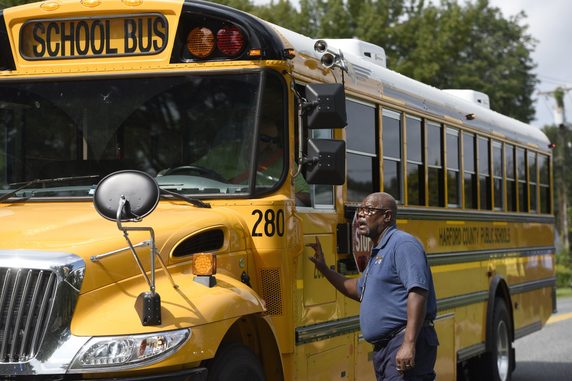 Tim Buffaloe, a chaplain from DayStar Advanced Response Ministerial Operations, talks to a bus driver who said he arrived to transport crime witnesses near the perimeter of a scene where a shooting took place in Aberdeen, Md. on Thursday, Sept. 20, 2018. (AP Photo/Steve Ruark)