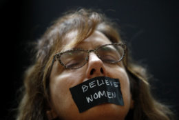 A protester wears a piece of tape over her mouth as she stands inside the Hart Senate Office Building on Capitol Hill in Washington, Thursday, Sept. 27, 2018. The Senate Judiciary Committee is scheduled to hear Thursday from Supreme Court nominee Brett Kavanaugh and Christine Blasey Ford, the woman who says he sexually assaulted her. (AP Photo/Patrick Semansky)