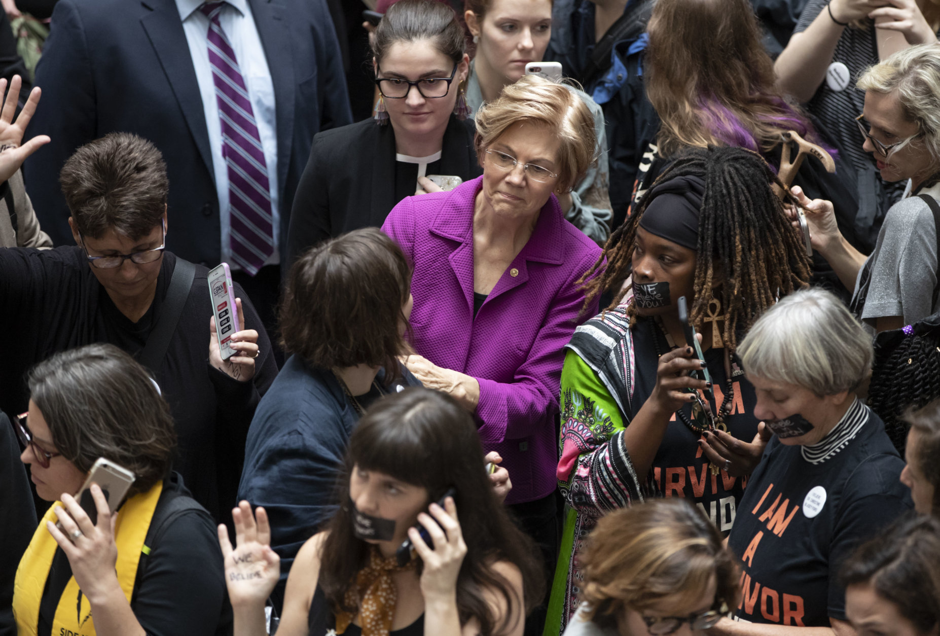 Sen. Elizabeth Warren, D-Mass., a vocal critic of Supreme Court nominee Brett Kavanaugh over the sexual harassment allegations made against him, greets womens' rights activists in the Hart Senate Office Building as the Senate Judiciary Committee hears from Kavanaugh and Christine Blasey Ford, his accuser, on Capitol Hill in Washington, Thursday, Sept. 27, 2018. (AP Photo/J. Scott Applewhite)