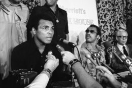 As world heavyweight champ Muhammad Ali, left, talks with reporters, challenger Ken Norton rises to leave a news conference on Wednesday, Sept. 29, 1976 at the Essex House hotel in New York, the day after Norton failed to take the world title from Ali in a 15-round bout at Yankee Stadium. Norton?s manager, Bob Biron, seated left behind Norton, sought to overturn the decision which gave Ali the title. (AP Photo/Marty Lederhandler