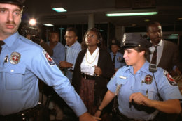 University of Oklahoma law professor Anita Hill, who accused U.S. Supreme Court nominee Judge Clarence Thomas of sexual harassment, leaves Washington's National Airport in Arlington, Va., amid heavy security, Friday, October 10, 1991.  Hill was to testify before the Senate Judiciary Committee Friday.  (AP Photo/Doug Mills)