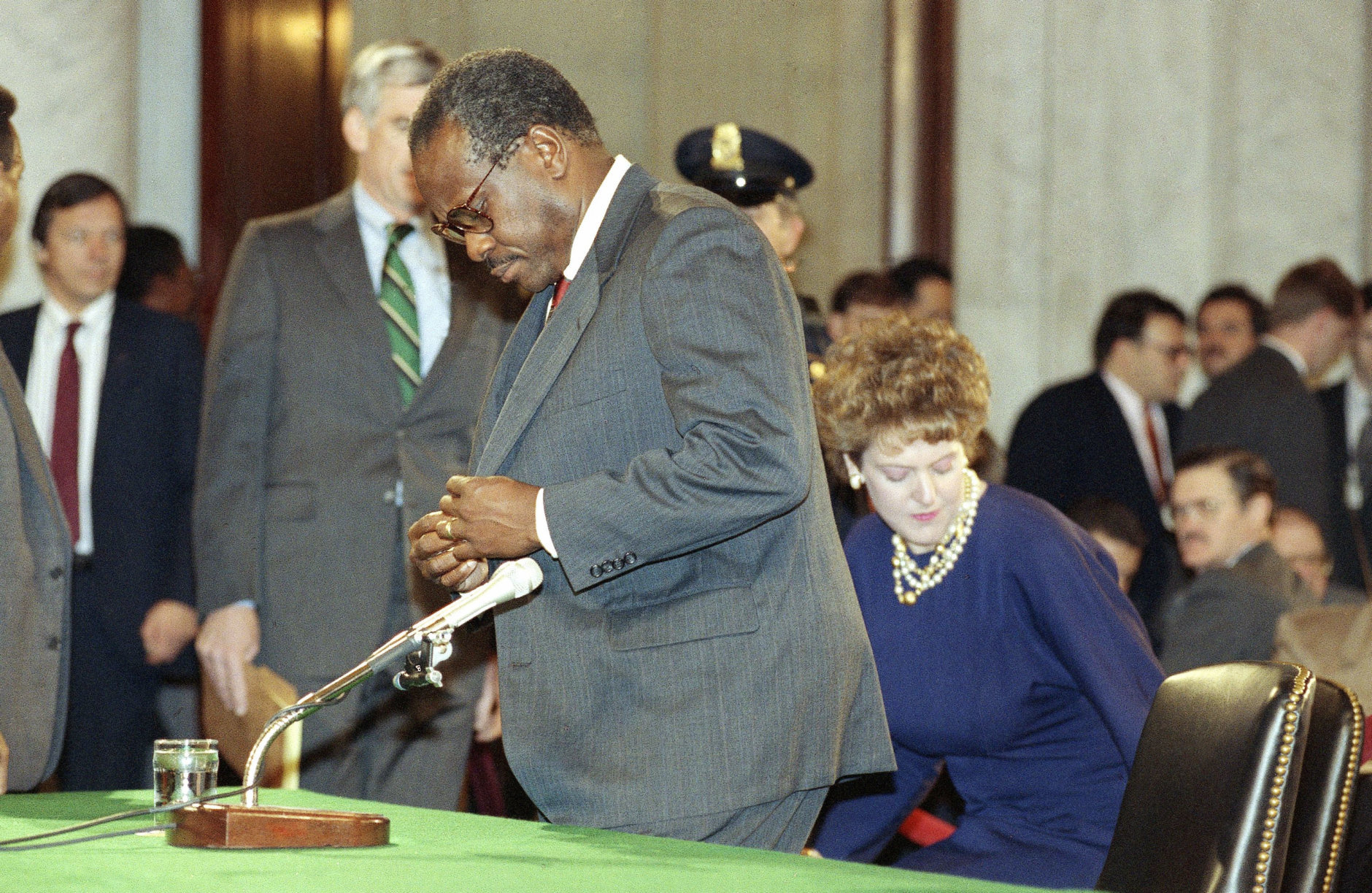 Judge Clarence Thomas prepares for another day of testimony before the Senate Judiciary Committee on Capitol Hill in Washington, Saturday, Oct. 12, 1991. Thomas flatly denied on Saturday that he had ever discussed pornographic movies with Anita Hill or anyone else in the workplace. Thomas? wife, Virginia, sits behind. (AP Photo/Greg Gibson)