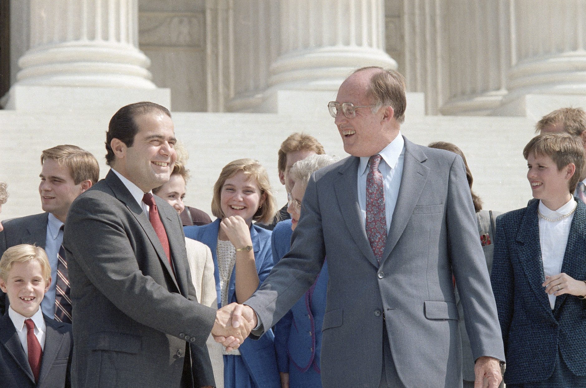 New Chief Justice of the Supreme Court William Rehnquist, right, shakes hands with the newest Associate Justice Antonin Scalia outside the Supreme Court Building in Washington, Sept. 26, 1986.  Rehnquist is the 16th chief justice and Scalia is the 103rd person to sit on the court.  (AP Photo/Barry Thumma)