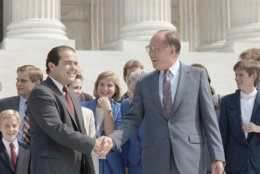 New Chief Justice of the Supreme Court William Rehnquist, right, shakes hands with the newest Associate Justice Antonin Scalia outside the Supreme Court Building in Washington, Sept. 26, 1986.  Rehnquist is the 16th chief justice and Scalia is the 103rd person to sit on the court.  (AP Photo/Barry Thumma)