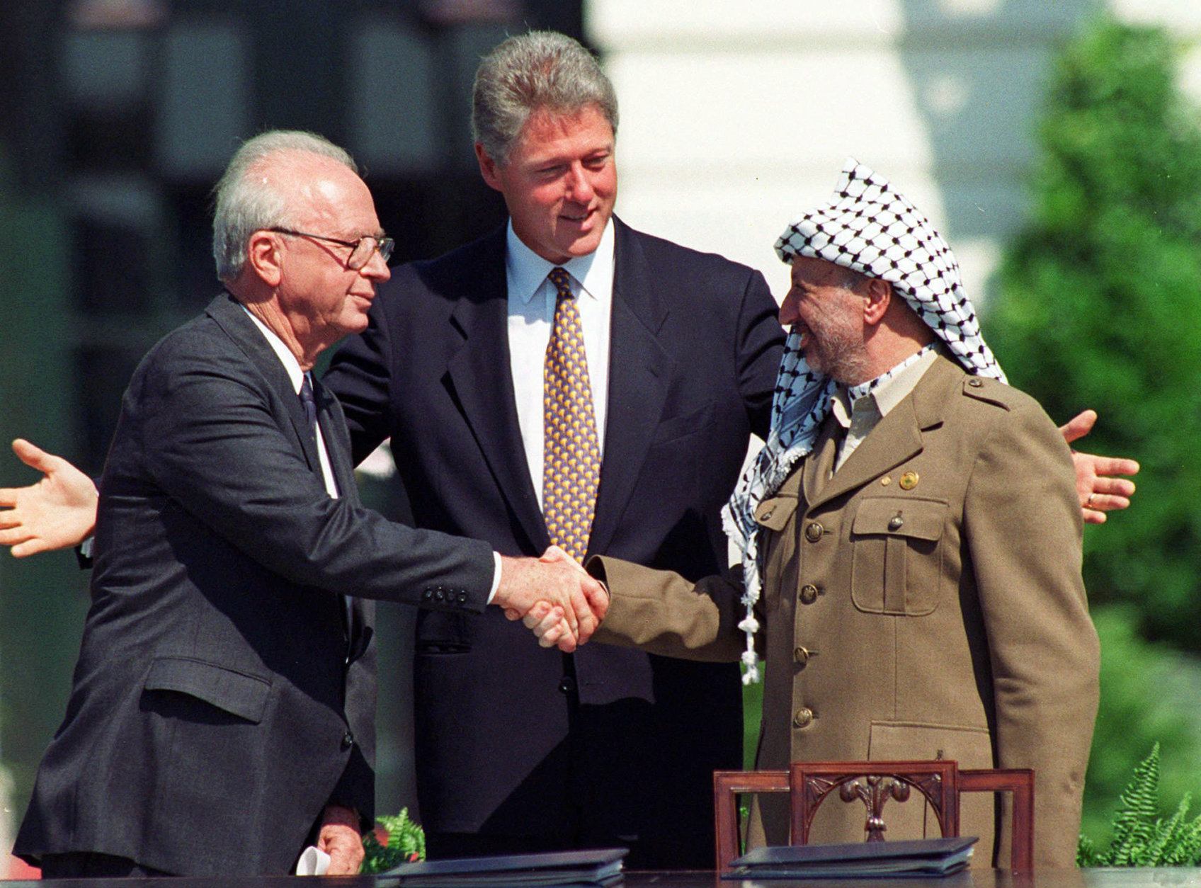 FILE -  In this Sept. 13, 1993 file photo President Clinton presides over White House ceremonies marking the signing of the peace accord between Israel and the Palestinians with Israeli Prime Minister Yitzhak Rabin, left, and Palestinian leader Yasser Arafat, right, in Washington.  In 1978, While President Jimmy Carter, Egypt’s Anwar Sadat and Israel’s Menachem Begin cemented the Camp David peace accord with a three-way handshake at the White House before the world’s cameras, the Palestinians were markedly absent. They hadn’t been included and references to the West Bank and Gaza did nothing to mollify anger among the stateless seeking a state.  (AP Photo/Ron Edmonds, File)