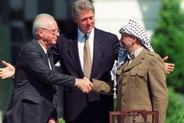 FILE -  In this Sept. 13, 1993 file photo President Clinton presides over White House ceremonies marking the signing of the peace accord between Israel and the Palestinians with Israeli Prime Minister Yitzhak Rabin, left, and Palestinian leader Yasser Arafat, right, in Washington.  In 1978, While President Jimmy Carter, Egypt’s Anwar Sadat and Israel’s Menachem Begin cemented the Camp David peace accord with a three-way handshake at the White House before the world’s cameras, the Palestinians were markedly absent. They hadn’t been included and references to the West Bank and Gaza did nothing to mollify anger among the stateless seeking a state.  (AP Photo/Ron Edmonds, File)