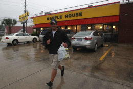 WILMINGTON, NC - SEPTEMBER 13: Josh Honeycutt runs to his car after picking up food at Waffle House, as the effects of Hurricane Florence start to hit the area, on September 13, 2018 in Wilmington, North Carolina. Hurricane Florence is expected on early Friday as a possible category 2 storm along the North Carolina and South Carolina coastline.  (Photo by Mark Wilson/Getty Images)