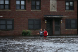 NEW BERN, NC - SEPTEMBER 13:  Residents wade through deep floodwater to retrieve belongings from the Trent Court public housing apartments after the Neuse River went over its banks during Hurricane Florence September 13, 2018 in New Bern, United States. Coastal cities in North Carolina, South Carolina and Virginia are under evacuation orders as the Category 2 hurricane approaches the United States.  (Photo by Chip Somodevilla/Getty Images)