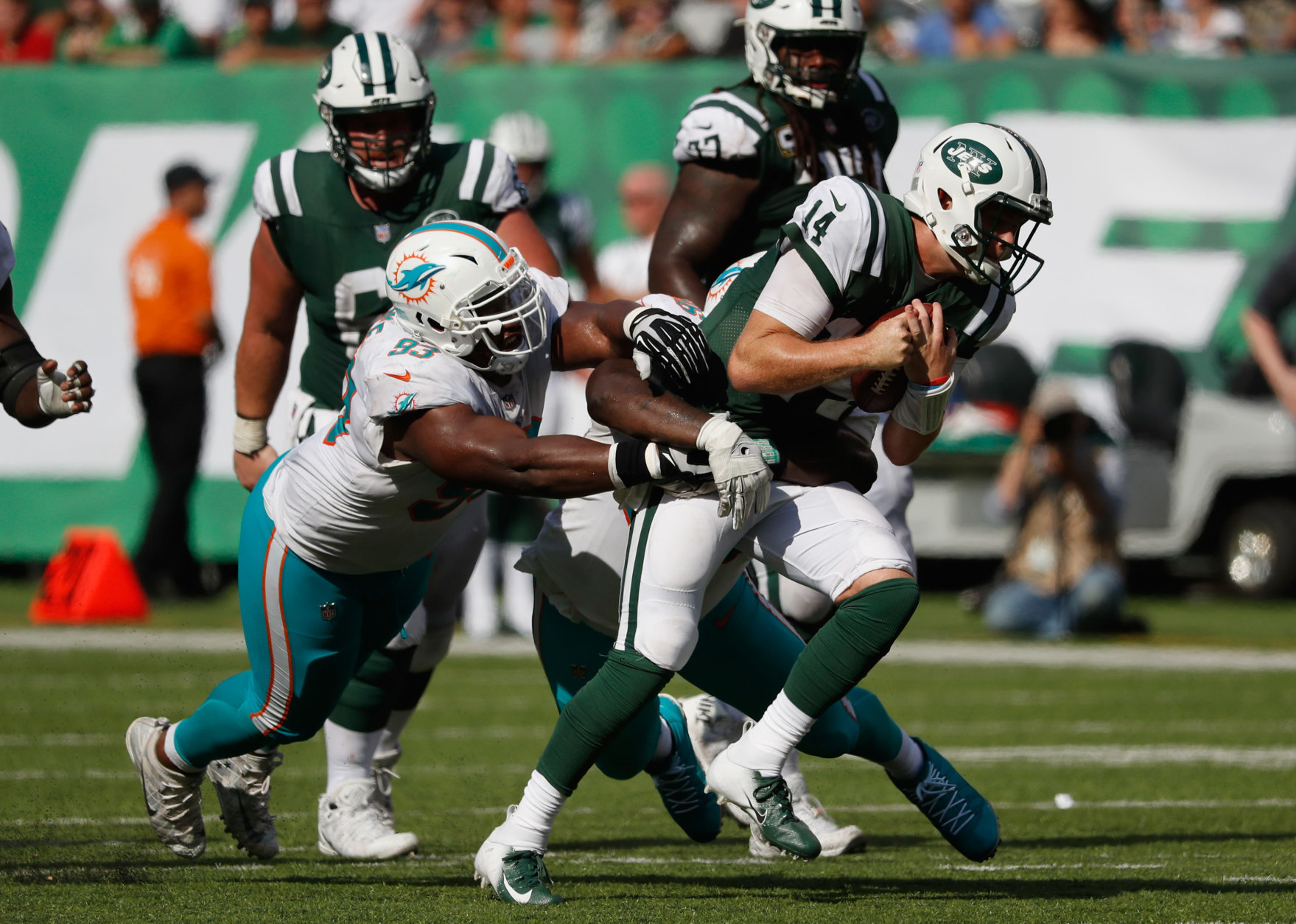 EAST RUTHERFORD, NJ - SEPTEMBER 16:  Quarterback Sam Darnold #14 of the New York Jets is tackled by defensive tackle Akeem Spence #93 and defensive tackle Vincent Taylor #96 of the Miami Dolphins during the second half at MetLife Stadium on September 16, 2018 in East Rutherford, New Jersey.  (Photo by Michael Owens/Getty Images)