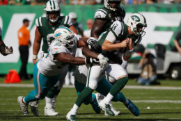 EAST RUTHERFORD, NJ - SEPTEMBER 16:  Quarterback Sam Darnold #14 of the New York Jets is tackled by defensive tackle Akeem Spence #93 and defensive tackle Vincent Taylor #96 of the Miami Dolphins during the second half at MetLife Stadium on September 16, 2018 in East Rutherford, New Jersey.  (Photo by Michael Owens/Getty Images)