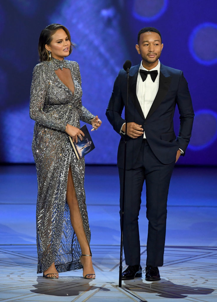 LOS ANGELES, CA - SEPTEMBER 17:  Chrissy Teigen (L) and John Legend speak onstage during the 70th Emmy Awards at Microsoft Theater on September 17, 2018 in Los Angeles, California.  (Photo by Kevin Winter/Getty Images)