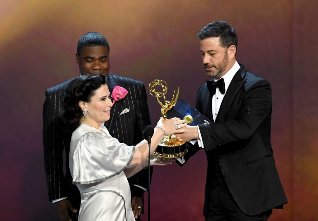 LOS ANGELES, CA - SEPTEMBER 17:  Alex Borstein (C) accepts the Outstanding Supporting Actress in a Comedy Series award for 'The Marvelous Mrs. Maisel' from Tracy Morgan (L) and Jimmy Kimmel (R) onstage during the 70th Emmy Awards at Microsoft Theater on September 17, 2018 in Los Angeles, California.  (Photo by Kevin Winter/Getty Images)