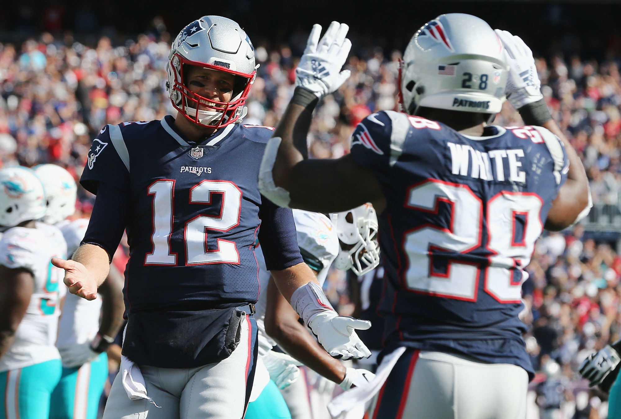 FOXBOROUGH, MA - SEPTEMBER 30:  Tom Brady #12 celebrates with James White #28 of the New England Patriots after scoring a touchdown during the third quarter against the Miami Dolphins at Gillette Stadium on September 30, 2018 in Foxborough, Massachusetts.  (Photo by Jim Rogash/Getty Images)