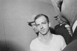 Lee Harvey Oswald is led down a corridor of the Dallas police station for another round of questioning in connection with the assassination of President John F. Kennedy, Nov. 23, 1963. Oswald, who denies any involvement in the shooting, is formally charged with murder.   (AP Photo)