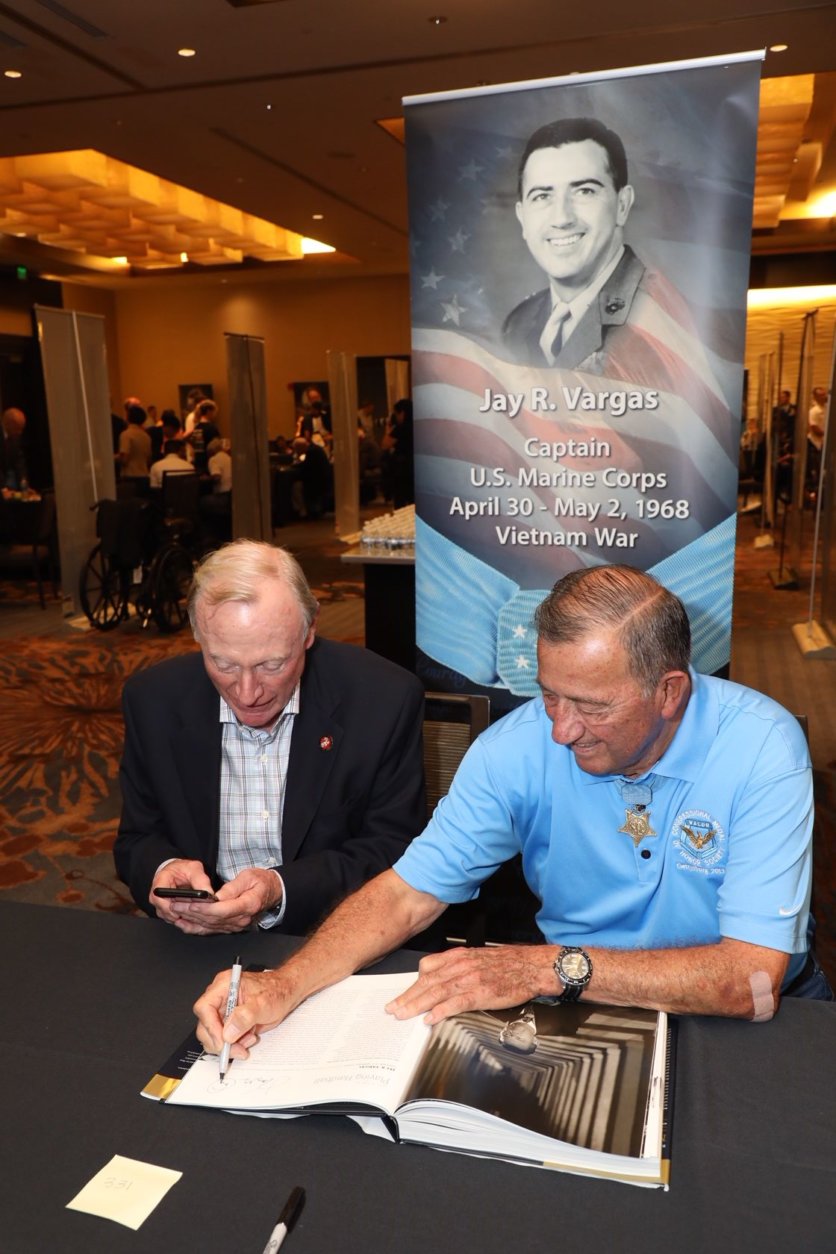 Congressional Medal of Honor recipient Jay Vargas autographs a book. (Courtesy Shmulik Almany/Congressional Medal of Honor Society)