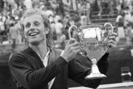 Vitas Gerulaitis holds up his trophy cup after winning the $300,000 Forest Hills Invitational Tournament in Queens, New York, Sunday, July 16, 1978.  Gerulaitis won the $100,000 first prize after defeating his opponent Ilie Nastase, 6-2, 6-0.  (AP Photo/Dave Pickoff)