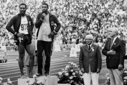 Two Olympic officials stand at attention, right, as U.S. runners Wayne Collett (978) and Vince Matthews stand at ease on the top level of the victory stand Sept. 7, 1972 at Olympic Stadium in Munich.  The crowd booed the two after Collett, who placed second in the 400-meter dash, joined first-place Matthews on the top level.  The two then stood at ease and sideways to the flag as the National Anthem was played in a protest of U.S. civil rights policies back home..  The International Olympic Committee banned the two from further competition although Matthews said later that no disrespect was intended. (AP Photo)