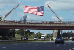 A flag is hoisted above US 50 at Church Road in Bowie, Maryland, as Sen. John McCain's funeral procession makes its way to the US Naval Academy in Annapolis, Maryland. (Courtesy Janelle Baliko)