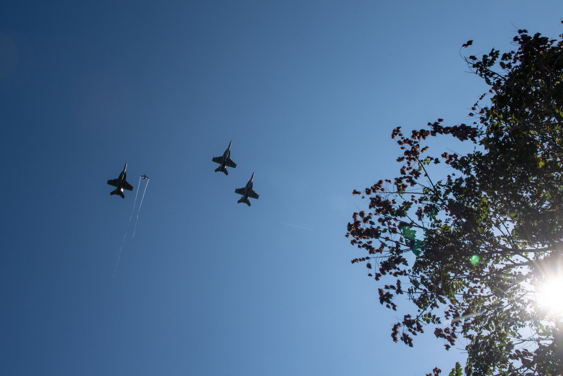F/A-18 Super Hornets from Strike Fighter Squadrons (VFA) 31, VFA-32, VFA-87 and VFA-105 honor the late Sen. John McCain with a fly-over of the United States Naval Academy during his burial service, Sept. 2, 2018. The aircraft were in missing man formation, which consists of four aircraft in a formation shape of a "V" with the right arm, from the pilots' perspective, longer than the left. When the "V" passes over the ceremonial site, the aircraft in the "ring-finger" position pulls up and leaves the formation to signify a lost comrade in arms. U.S. Navy photo by Mass Communication Specialist 2nd Class Nathan Burke. (Courtesy U.S. Naval Academy Public Affairs)