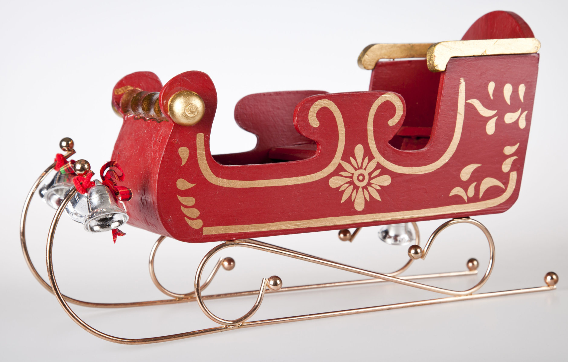 "Classic Wooden toy Santa Sleigh, with gold trimmings, and silvers bells. Shot on white background side view."