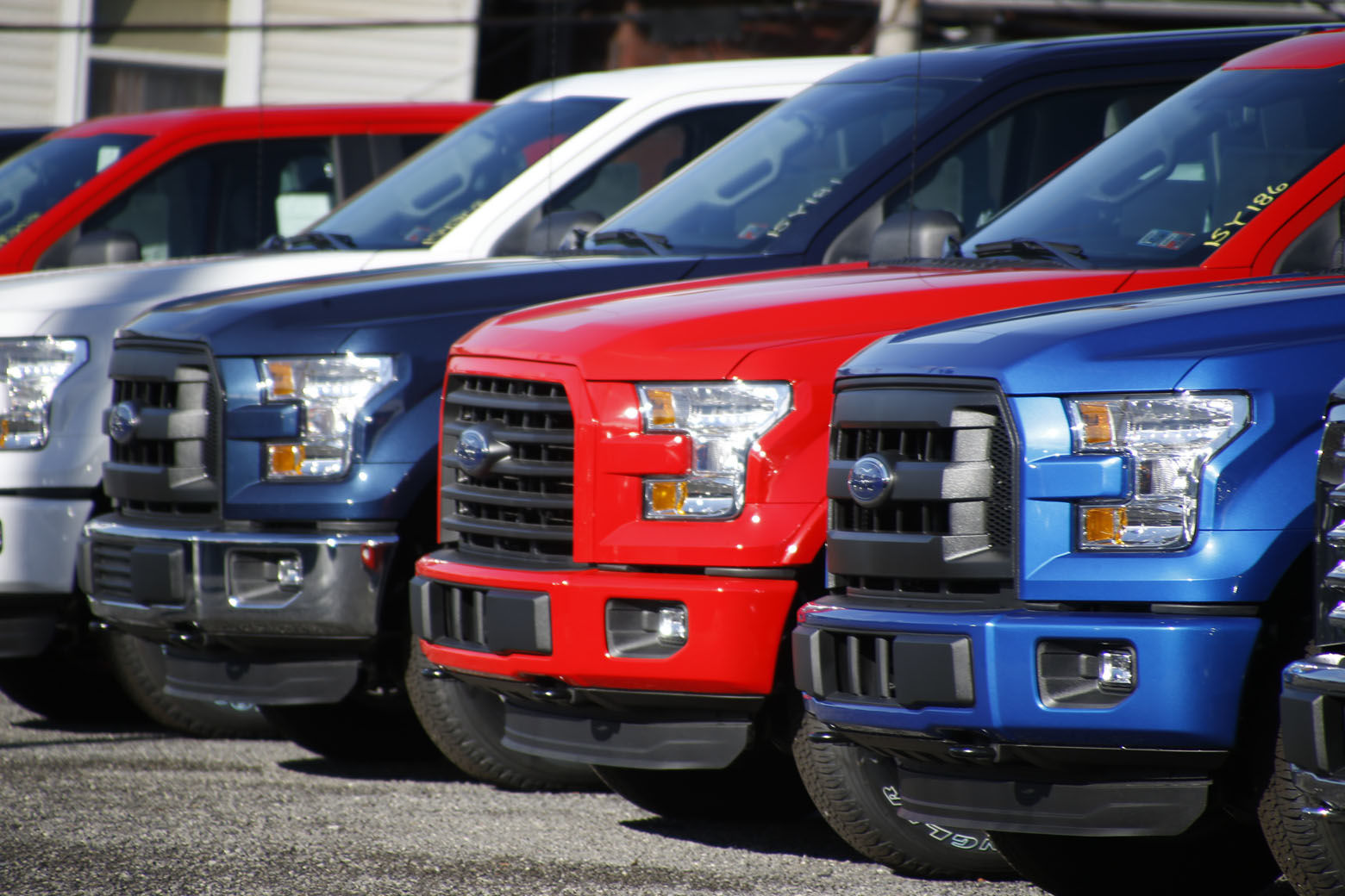FILE- In this Nov. 19, 2015, file photo a row of 2015 Ford F-150 pickup trucks are parked on the sales lot at Butler County Ford in Butler, Pa. Under pressure from U.S. safety regulators, Ford is recalling about 2 million F-150 pickups in North America because the seat belts can cause fires. The recall covers certain trucks from the 2015 through 2018 model years. (AP Photo/Keith Srakocic, File)