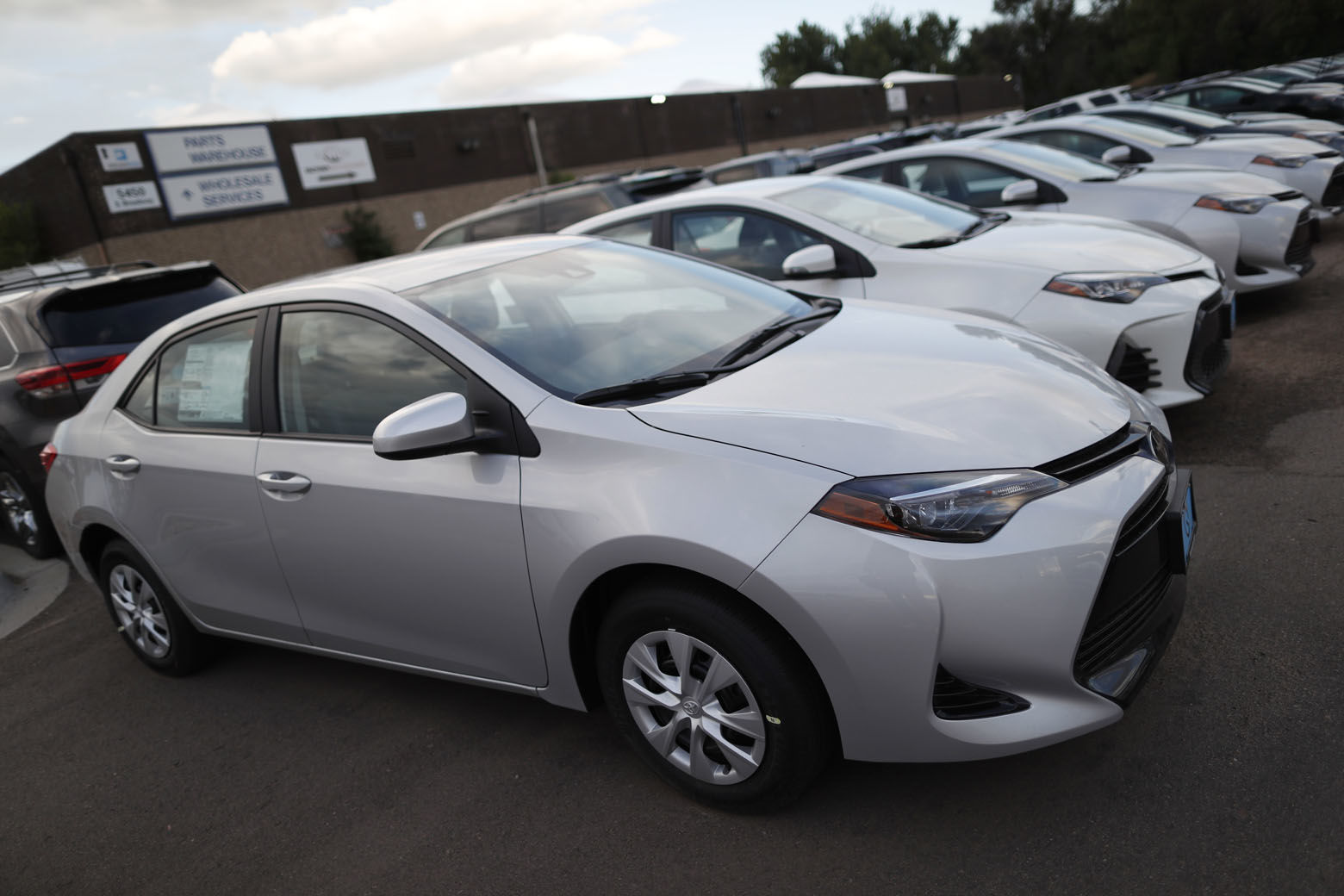 In this Sunday, June 24, 2018, photograph, unsold 2018 Corolla sedans sit at a Toyota dealership in Englewood, Colo. (AP Photo/David Zalubowski)