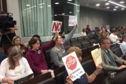Residents holding signs which read, “Don’t widen 270 & 495” attended a public meeting Thursday, Oct. 11, 2018. (WTOP/Mike Murillo)