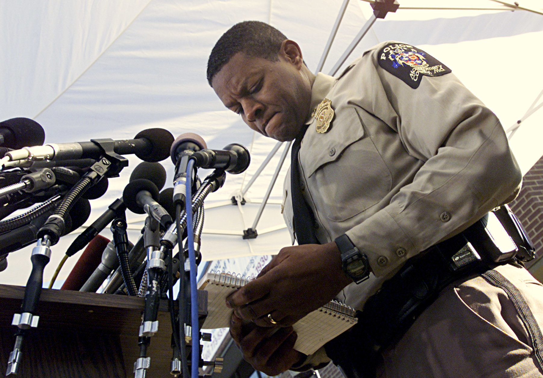 Montgomery County Police Chief Charles A. Moose reads from a notebook as he delivers another message to an unspecified individual during an evening news conference Monday, Oct. 21, 2002 in Rockville, Md.  (AP Photo/Victoria Arocho)