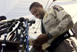 Montgomery County Police Chief Charles A. Moose reads from a notebook as he delivers another message to an unspecified individual during an evening news conference Monday, Oct. 21, 2002 in Rockville, Md.  (AP Photo/Victoria Arocho)