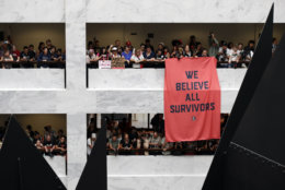 Protesters hang a banner as they gather in the atrium of the Hart Senate Office Building on Capitol Hill, Thursday, Oct. 4, 2018 in Washington. (AP Photo/Alex Brandon)