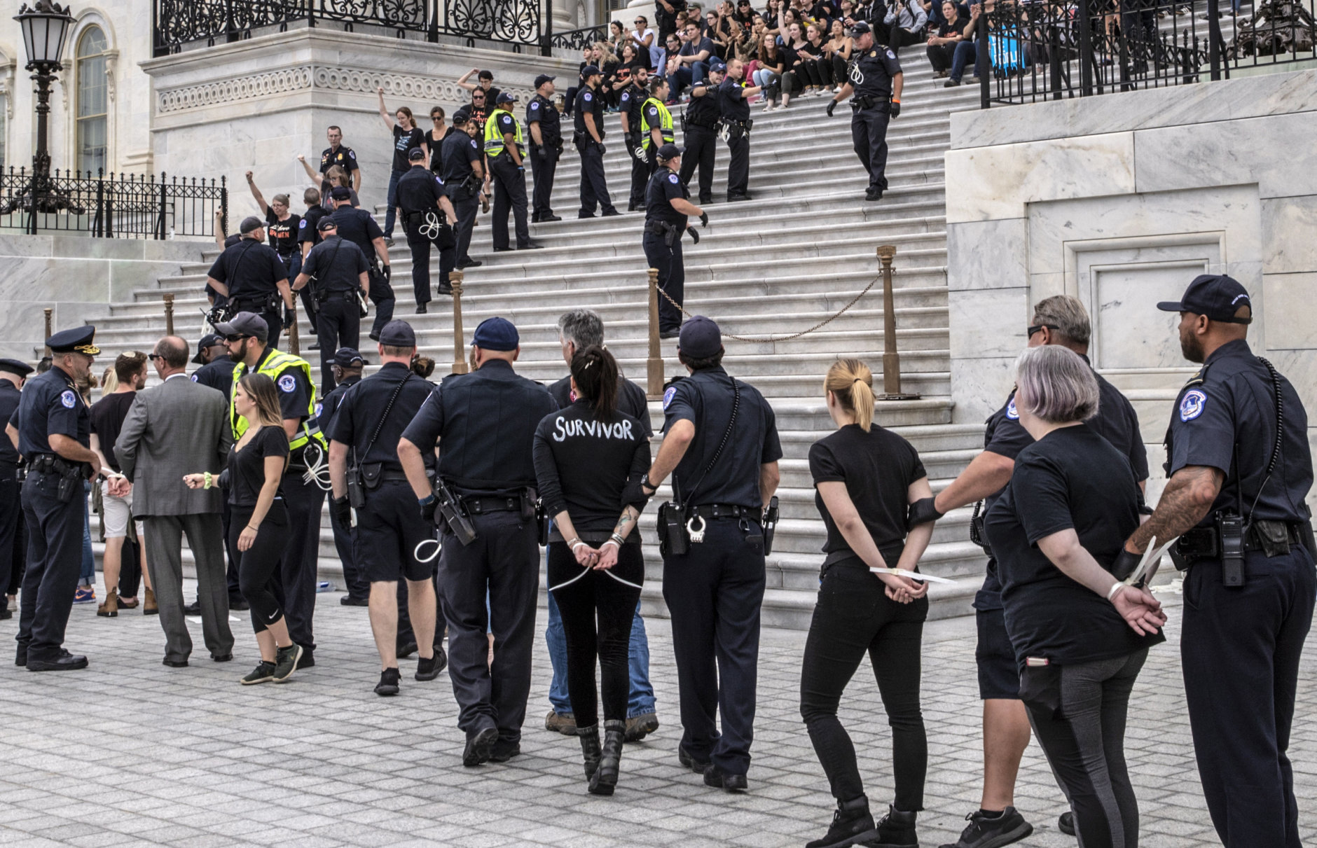 Crowds of activists are arrested after they rushed past barriers and protested from the steps of the Capitol before the confirmation vote on President Donald Trump's Supreme Court nominee, Brett Kavanaugh, in Washington, Saturday, Oct. 6, 2018. (AP Photo/J. Scott Applewhite)