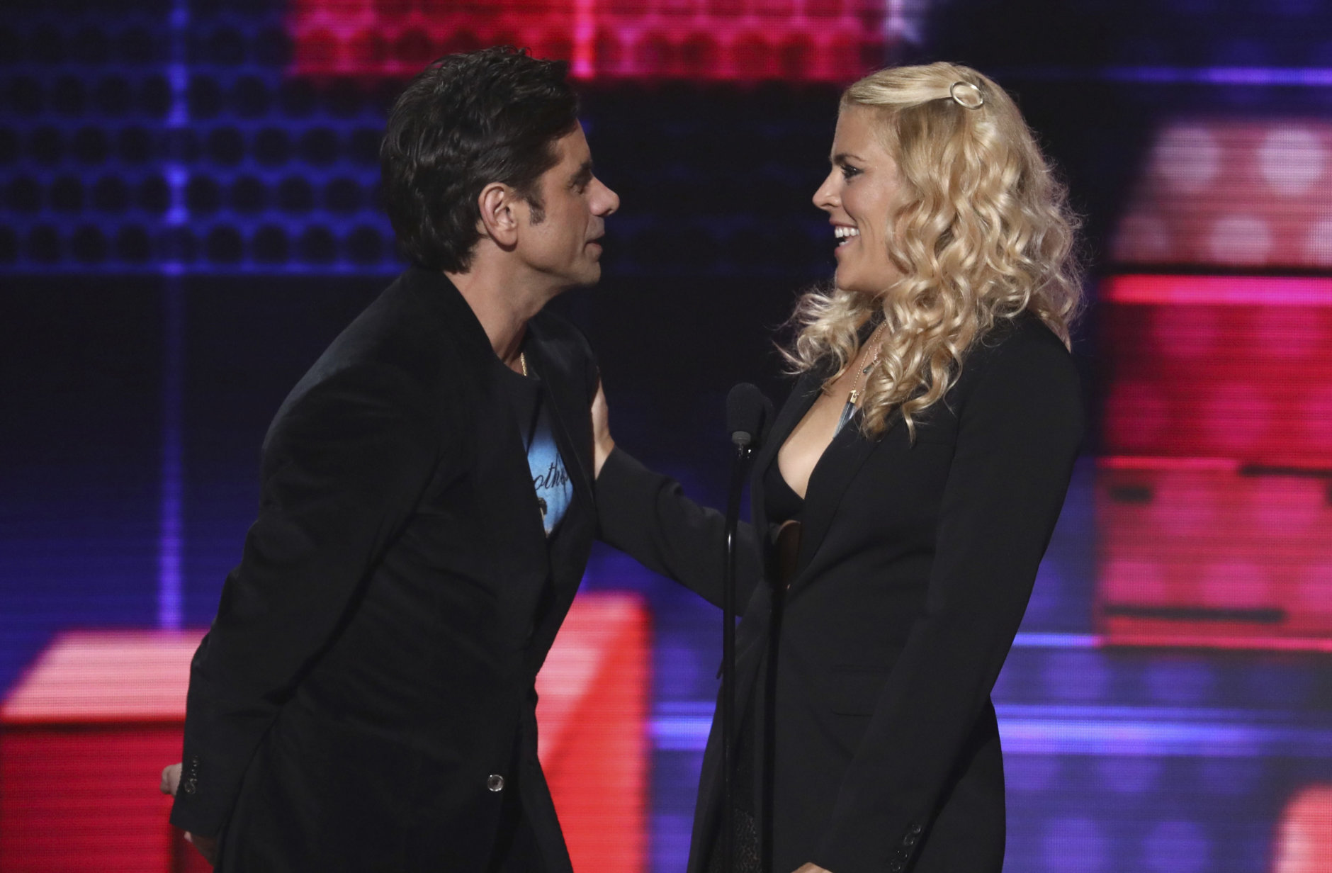 John Stamos, left, and Busy Phillips present the award for favorite male soul/R&amp;B artist at the American Music Awards on Tuesday, Oct. 9, 2018, at the Microsoft Theater in Los Angeles. (Photo by Matt Sayles/Invision/AP)