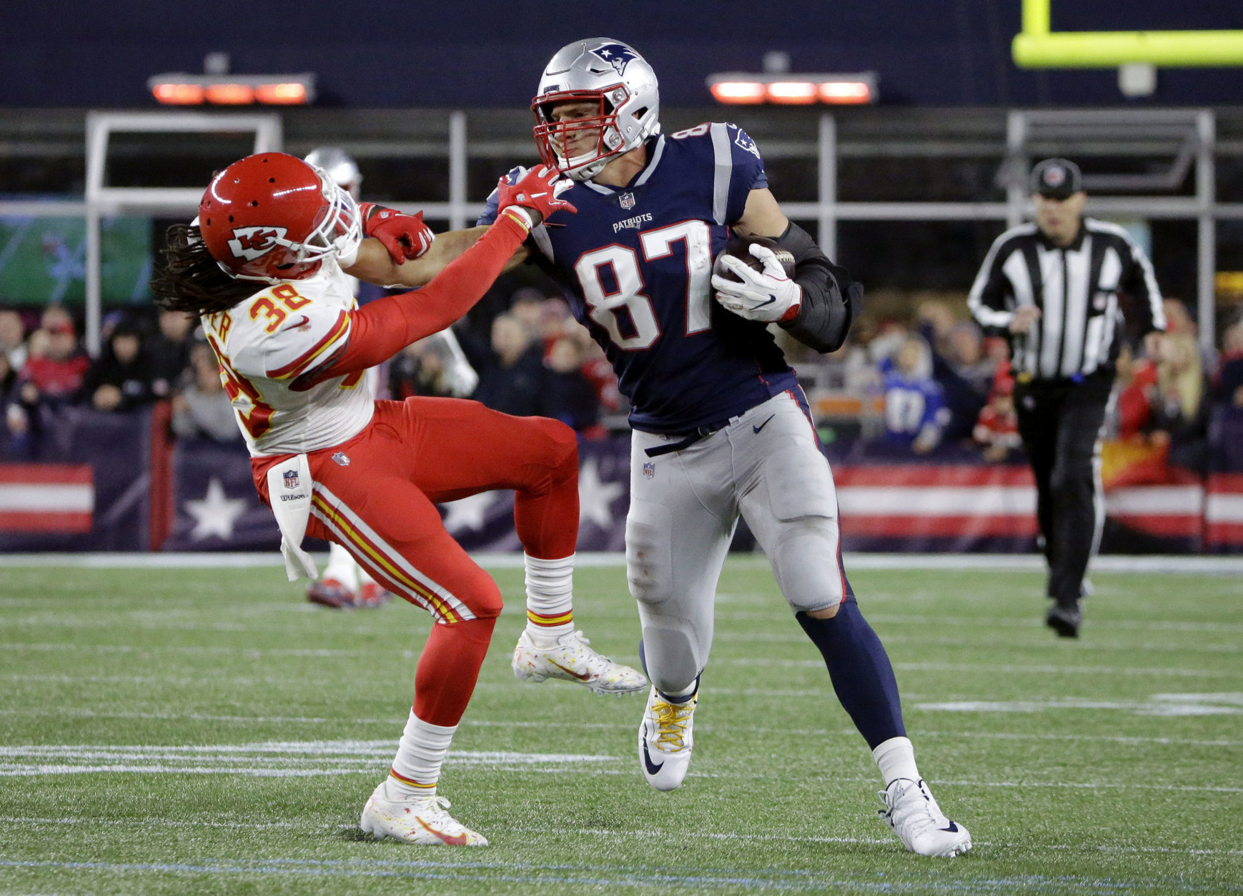 New England Patriots tight end Rob Gronkowski (87) gives a stiff arm to Kansas City Chiefs free safety Ron Parker (38) after catching a pass during the second half of an NFL football game, Sunday, Oct. 14, 2018, in Foxborough, Mass. (AP Photo/Steven Senne)