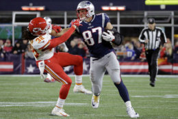 New England Patriots tight end Rob Gronkowski (87) gives a stiff arm to Kansas City Chiefs free safety Ron Parker (38) after catching a pass during the second half of an NFL football game, Sunday, Oct. 14, 2018, in Foxborough, Mass. (AP Photo/Steven Senne)