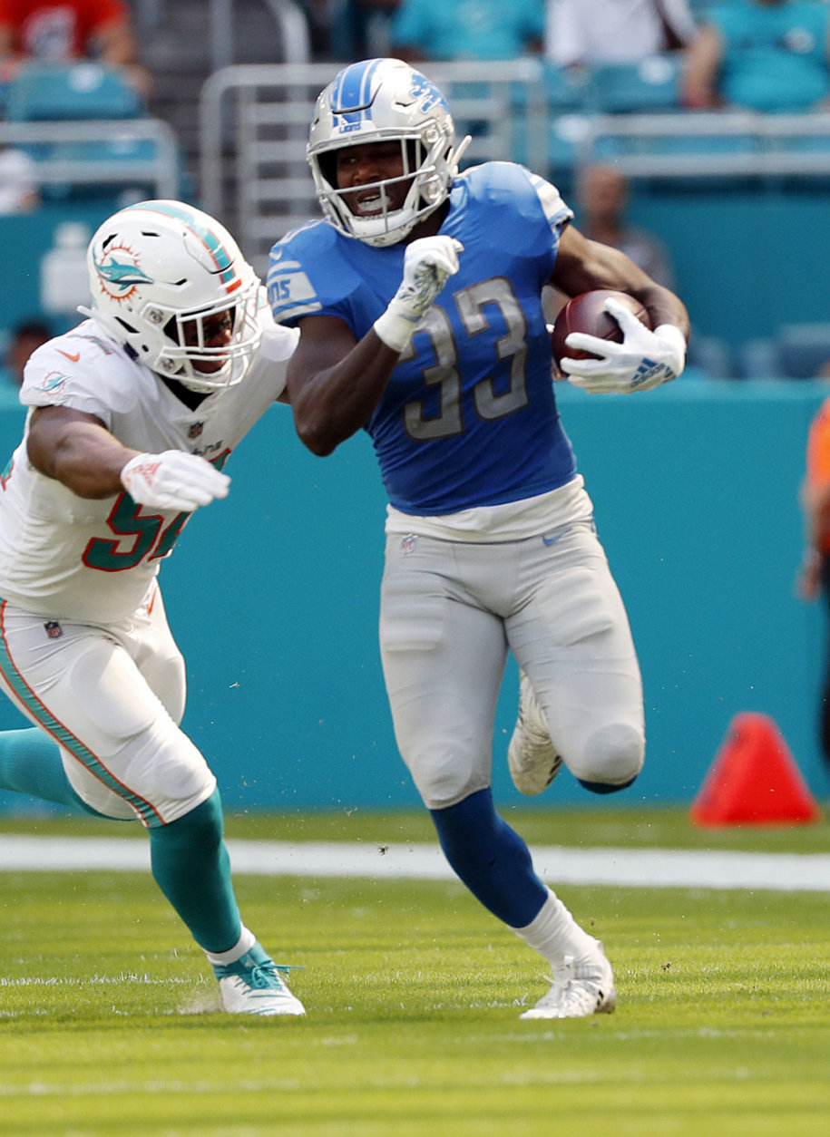 Detroit Lions running back Kerryon Johnson (33) carries the ball as Miami Dolphins linebacker Raekwon McMillan (52) attempts to tackle, during the first half of an NFL football game against the Miami Dolphins, Sunday, Oct. 21, 2018, in Miami Gardens, Fla. (AP Photo/Wilfredo Lee)